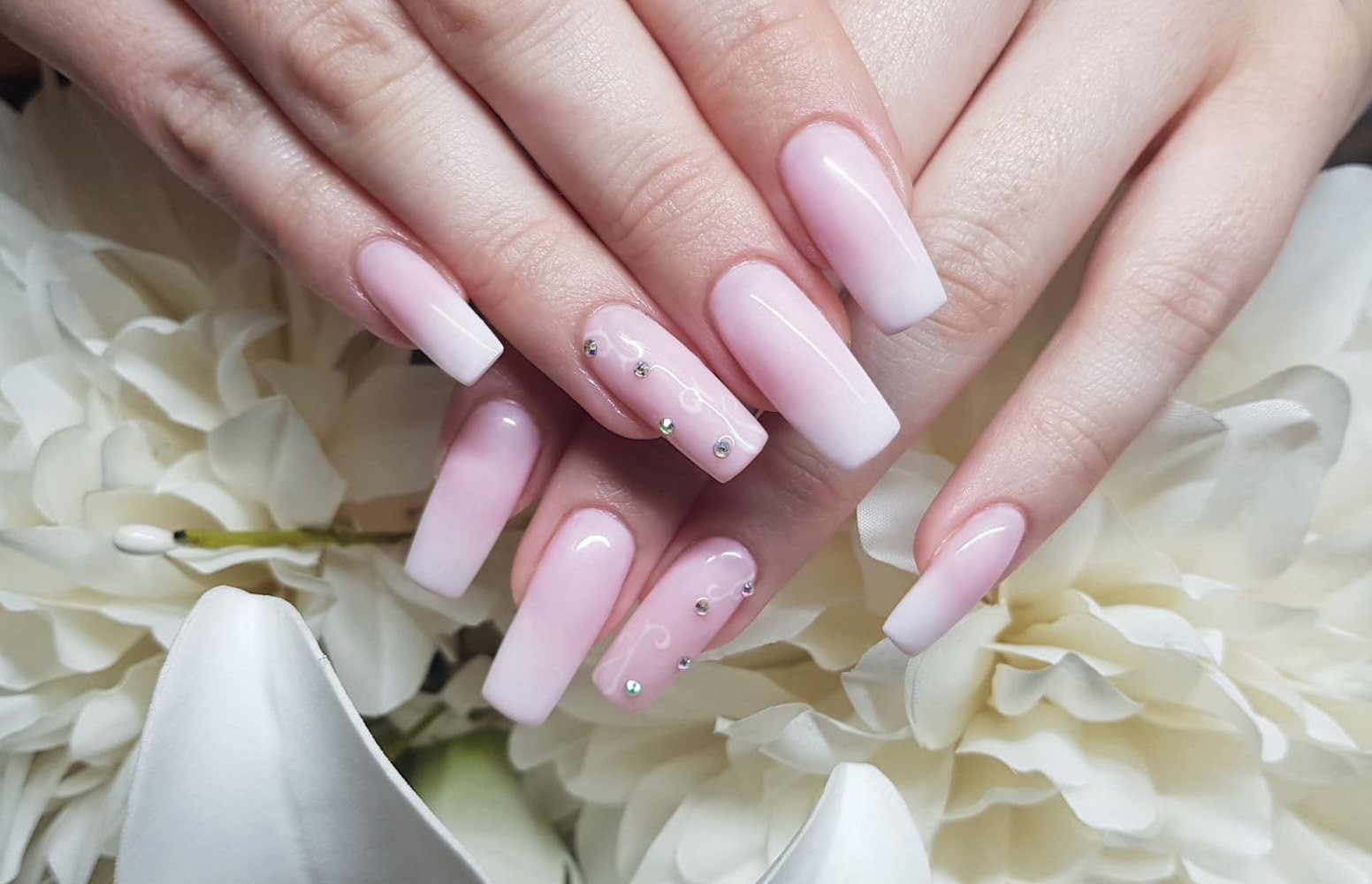 Pale pink nails with white tips and gold accents