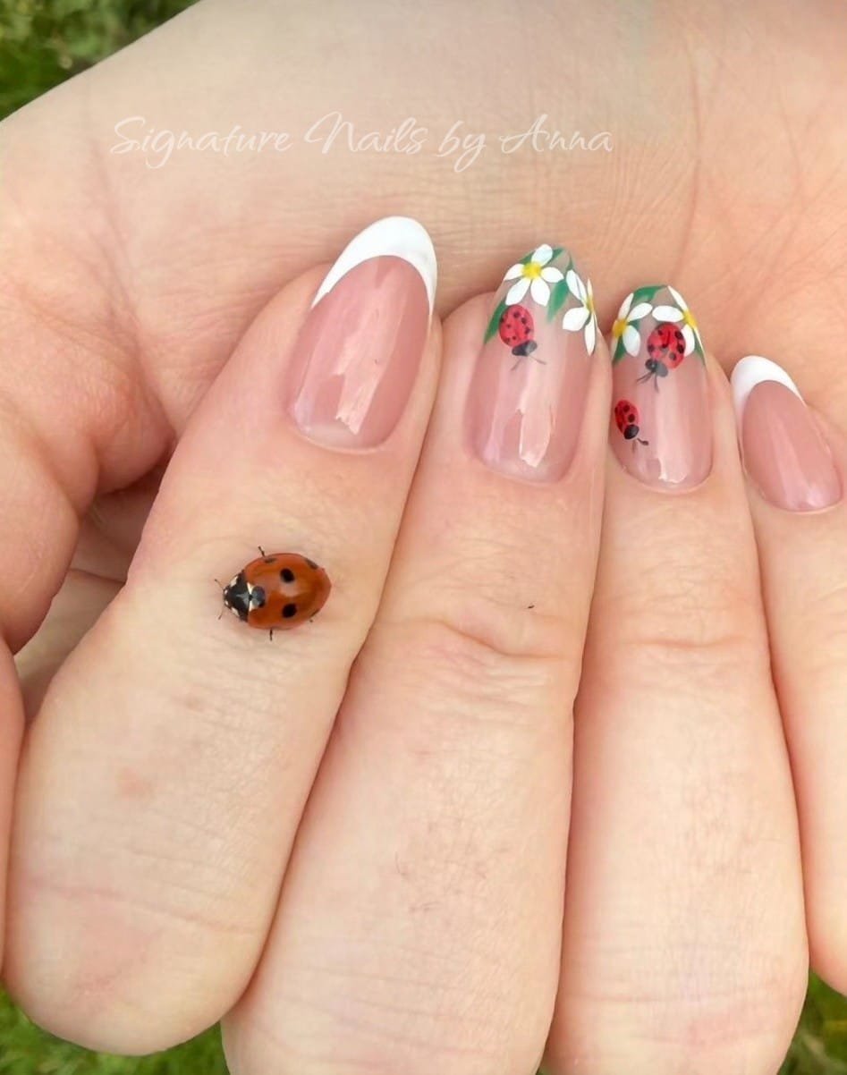 Pink and white nails with colourful floral detail and a ladybird design