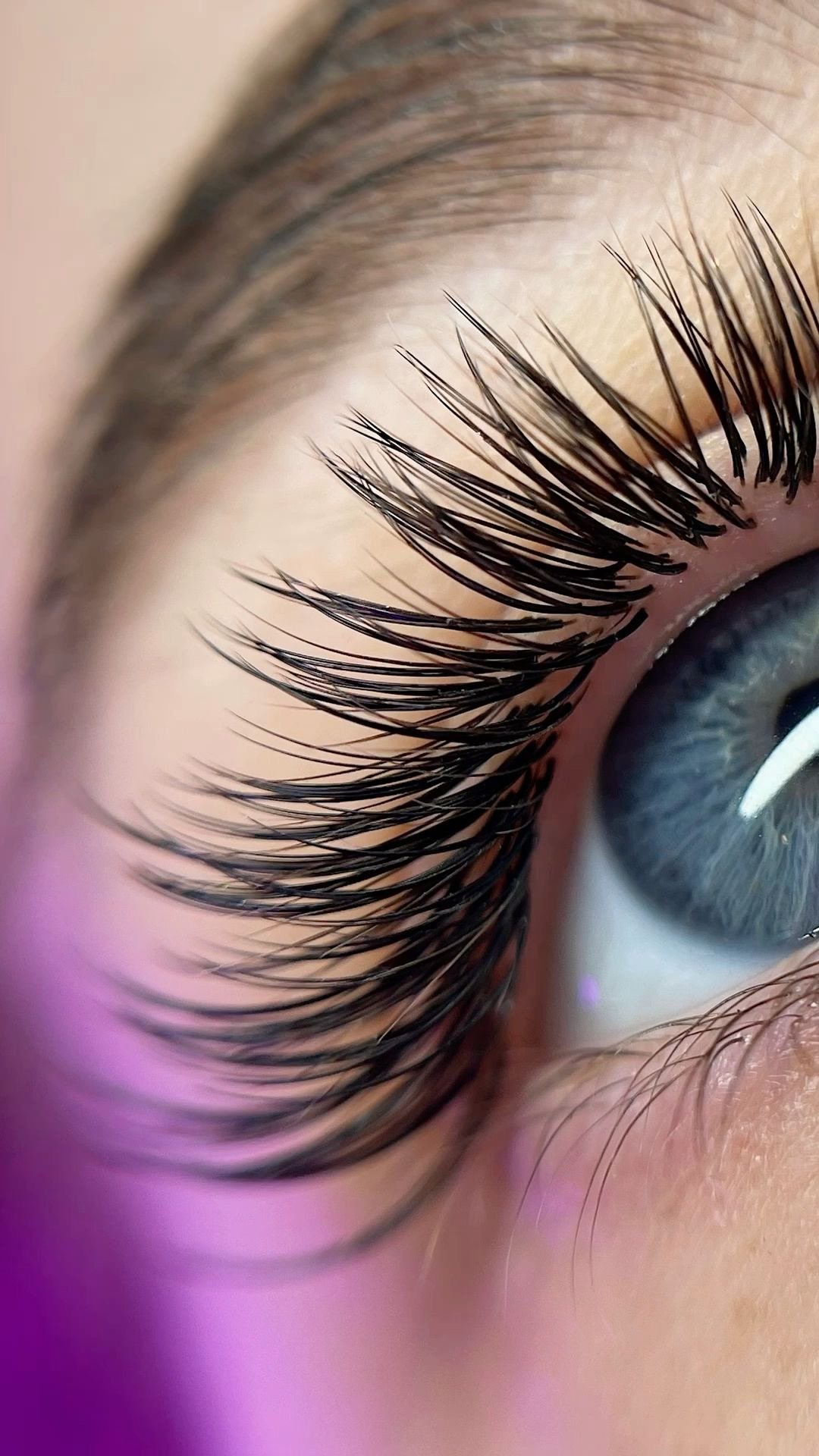 Close-up of a blue eye with curled lash extensions